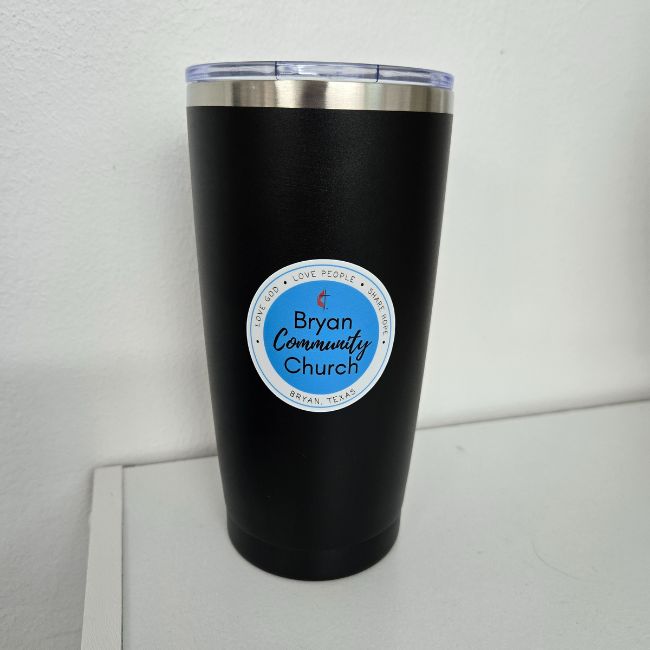 Black insulated tumbler with a 'Bryan Community Church' label on a white surface.
