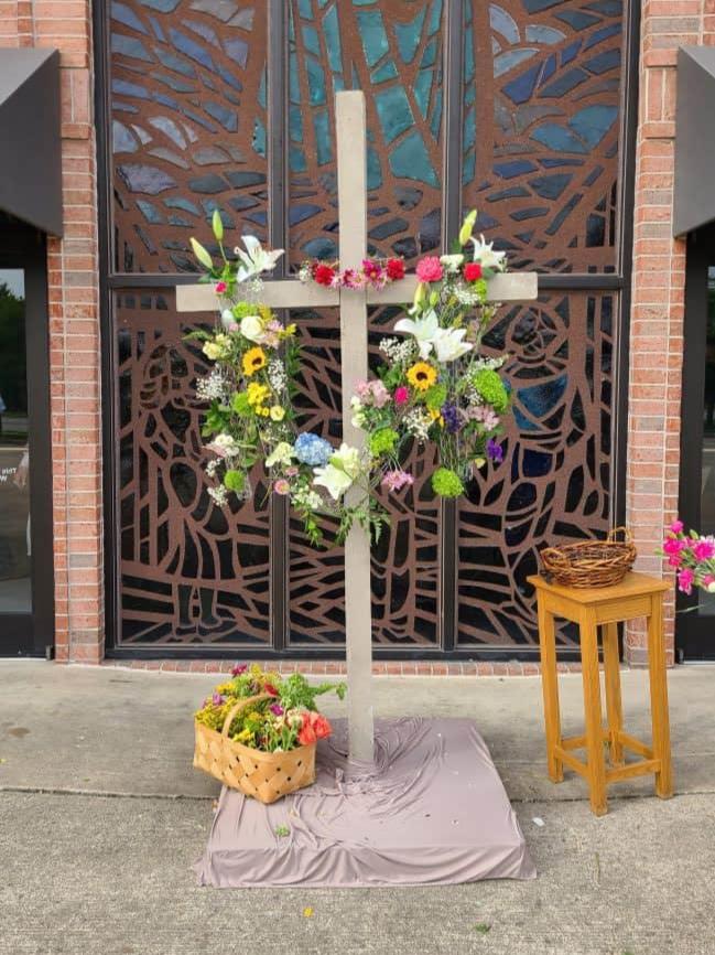 wooden cross draped with flowers on Easter Sunday